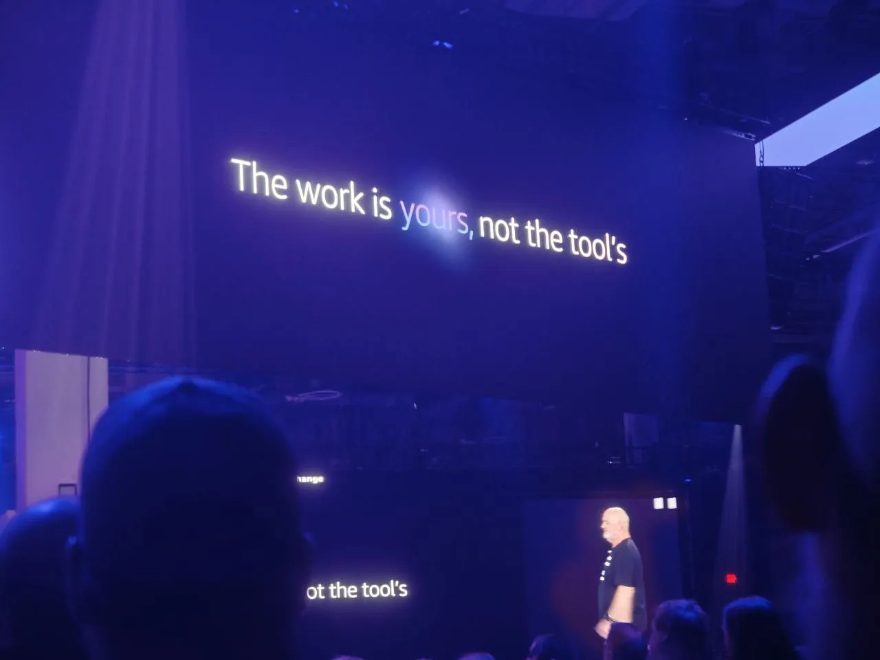 A photo taken from the audience of Werner Vogels' keynote, of a slide stating that 'The work is yours, not the tool's.